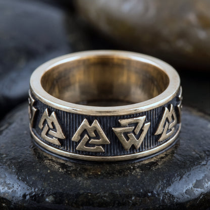 Close view of the raised valknut symbols and striated oxidised ground on the bronze band
