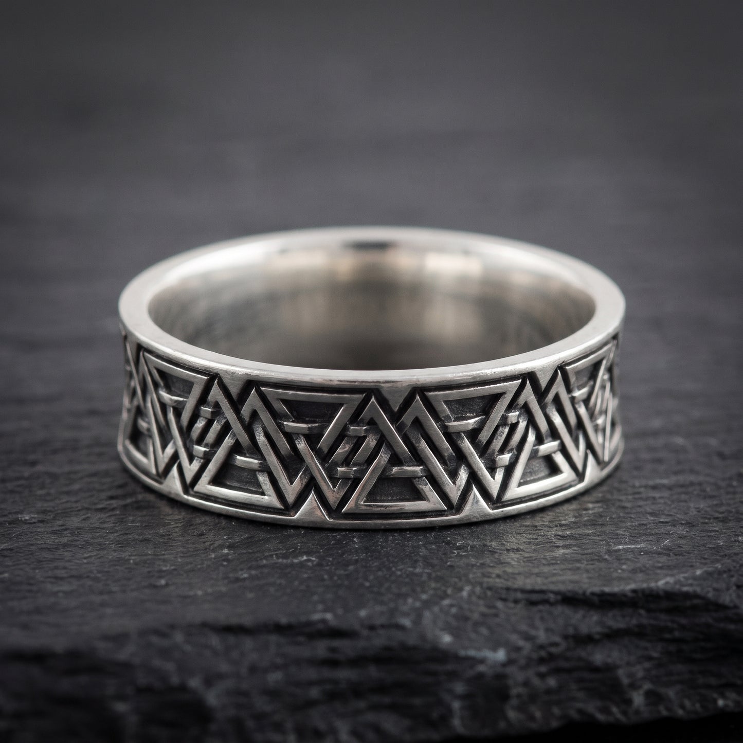 Close view of the interlocking valknut symbols on the oxidised silver band