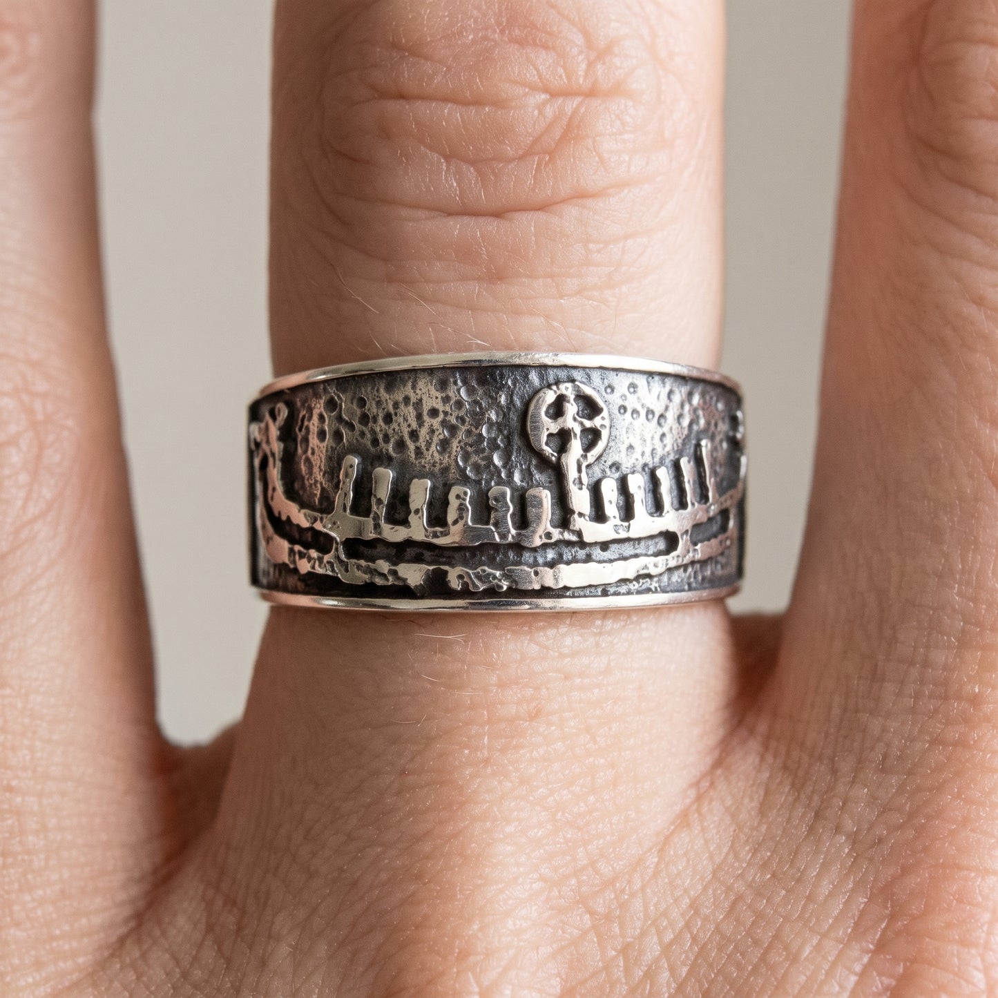 Silver Viking wedding ring with a drakkar longship worn on a finger
