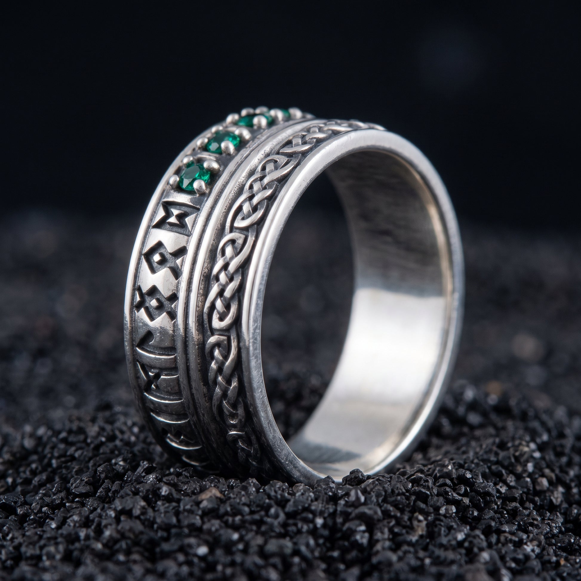 Sterling silver Viking wedding ring with Elder Futhark runes and green cubic zirconia on black volcanic sand