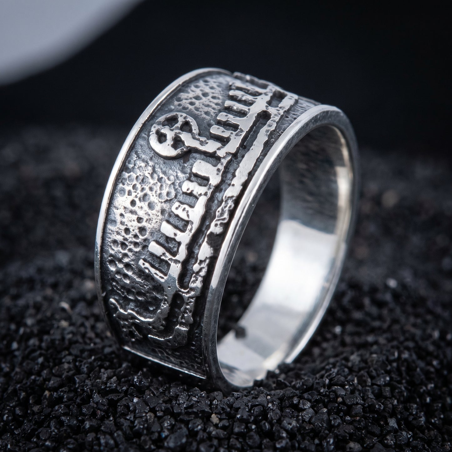 Sterling silver Viking wedding ring with a Norse drakkar longship in relief, on black volcanic sand