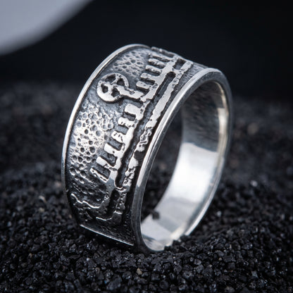 Sterling silver Viking wedding ring with a Norse drakkar longship in relief, on black volcanic sand